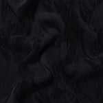 Draped black large leaf jacquard showing movement for jackets, dresses and skirts.