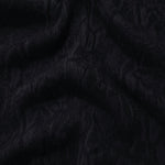 Draped black ornamental floral jacquard showing textured movement for dresses.