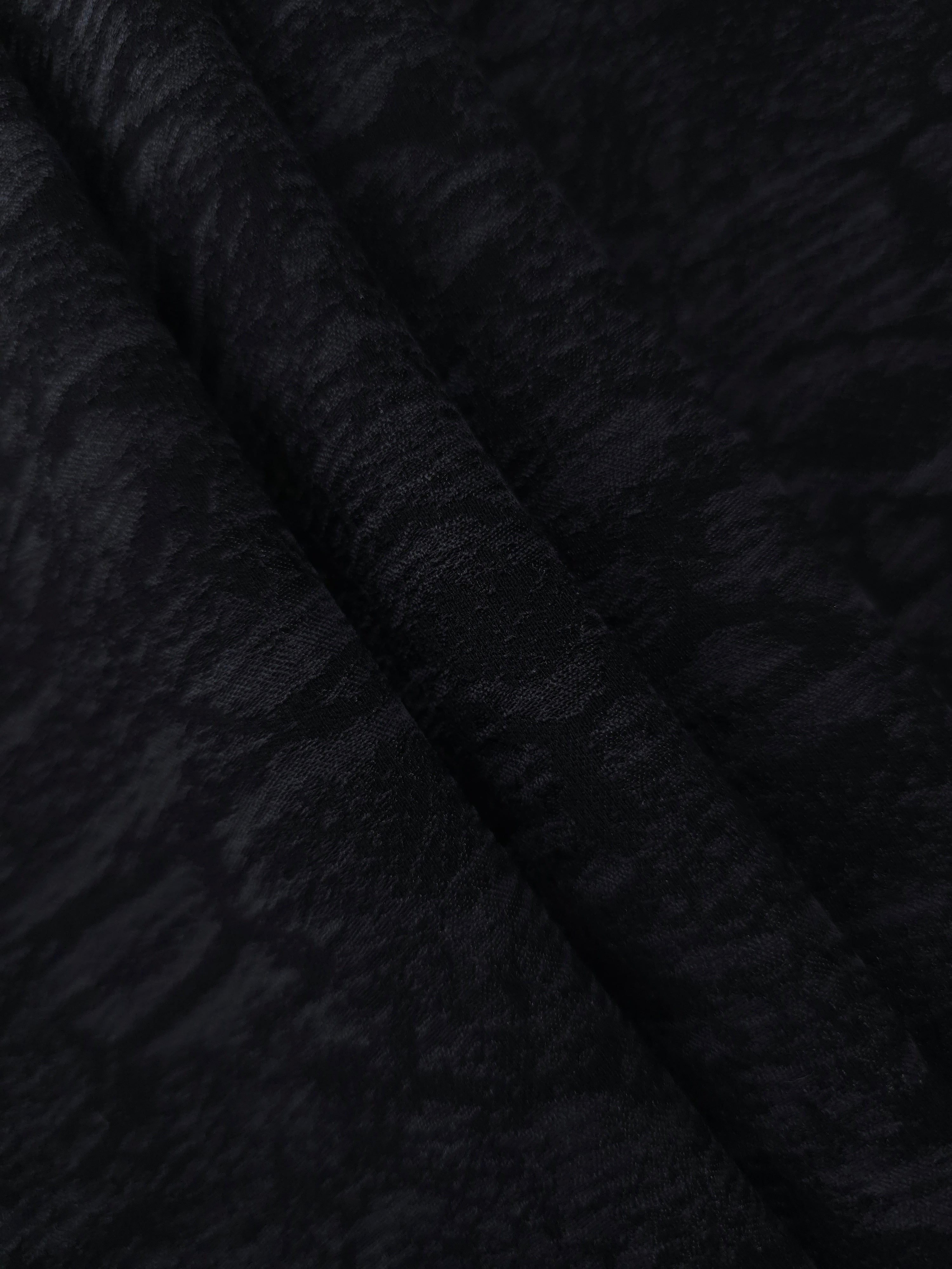 Folded black ornamental floral lyocell viscose jacquard for skirts and jackets.
