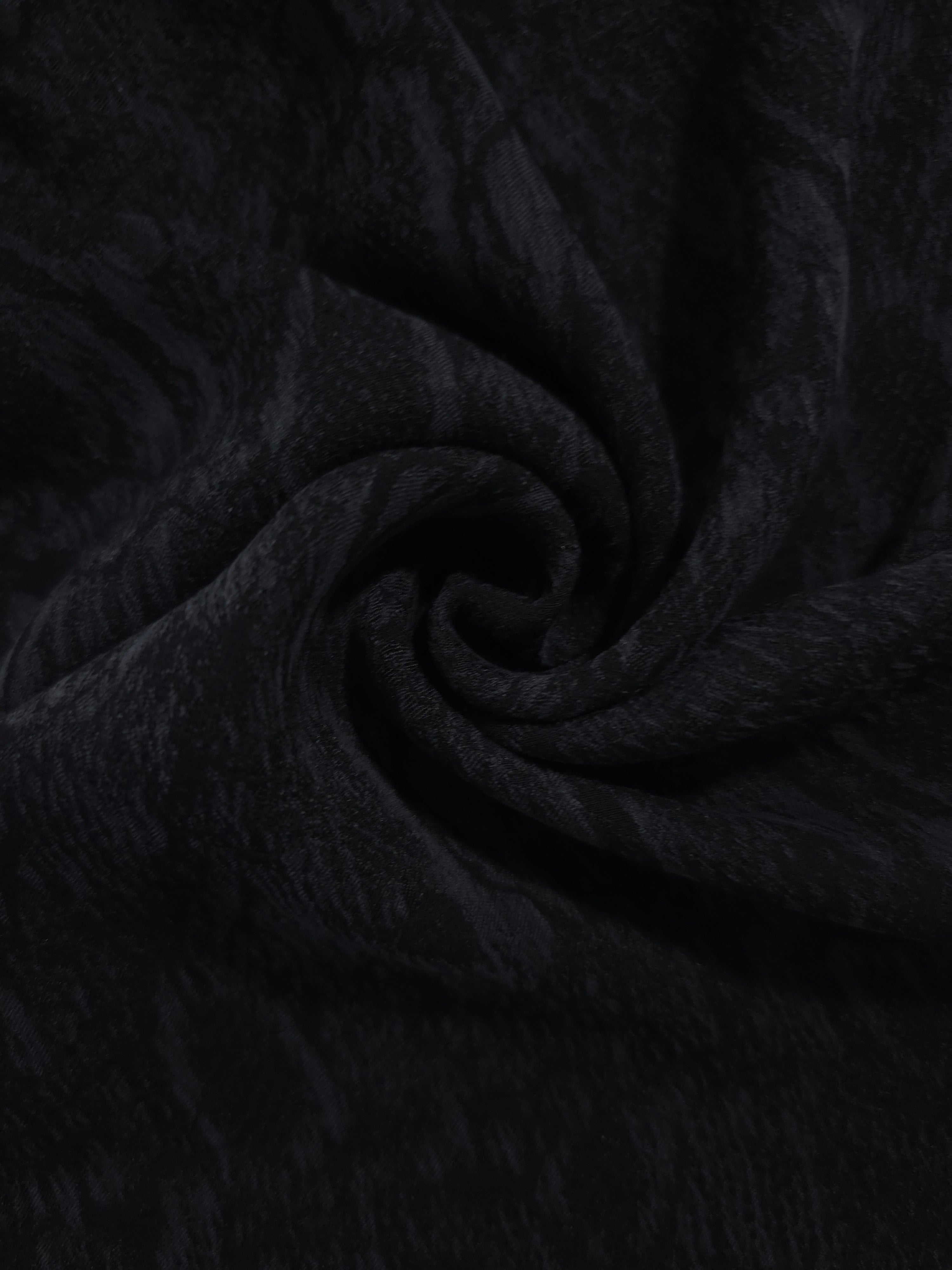 Swirl drape of black ornamental floral jacquard with darker tonal surface pattern.