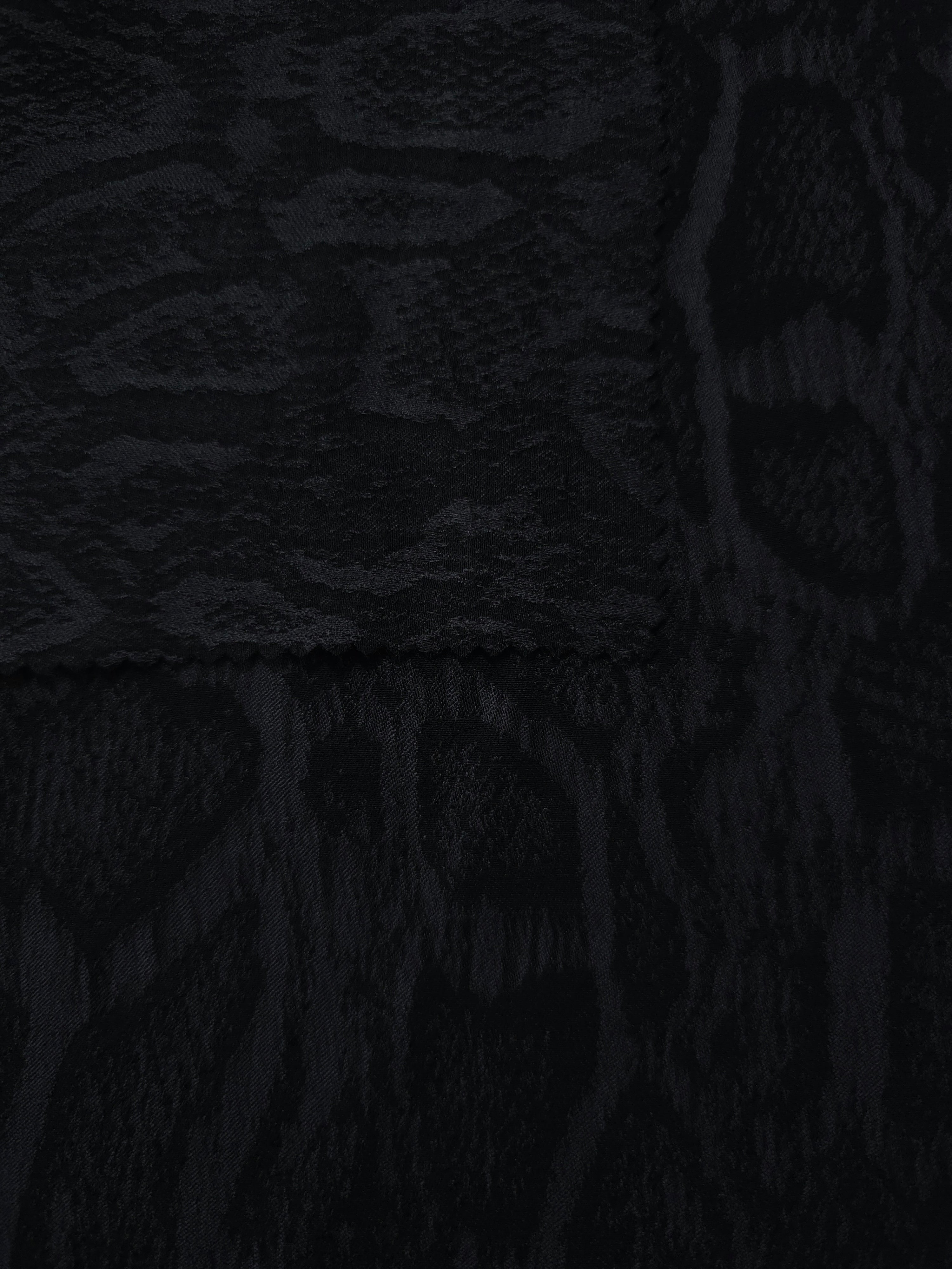 Selvage detail of black paisley vine lyocell viscose jacquard fabric.