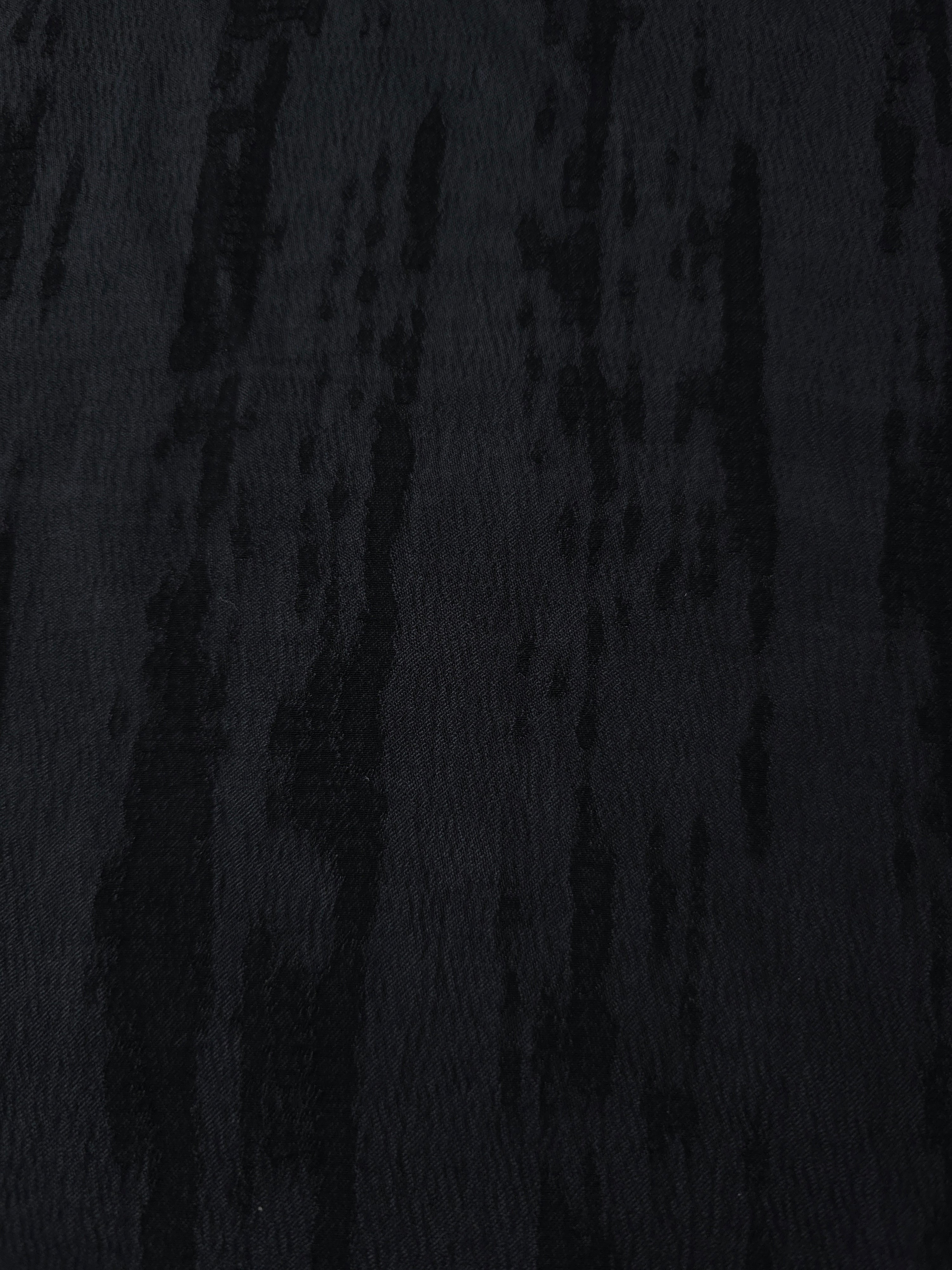 Close texture of tonal black bark stripe jacquard in lyocell viscose for fashion sewing.
