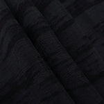 Folded tonal black vertical bark jacquard for skirts, jackets and layered garments.