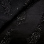 Close-up of Metallic Black viscose jacquard with gold metallic brushstroke embossing