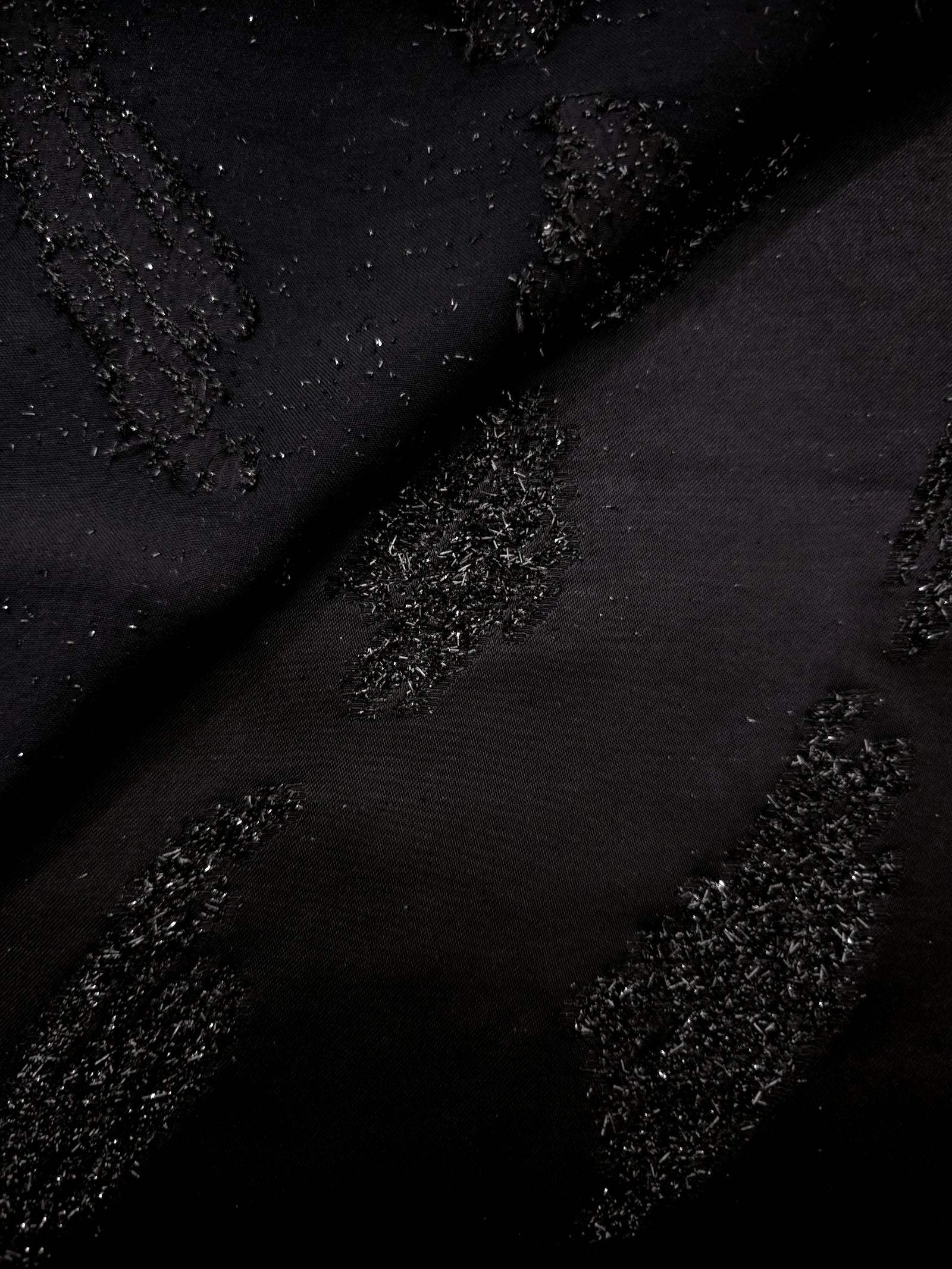 Close-up of Metallic Black viscose jacquard with gold metallic brushstroke embossing