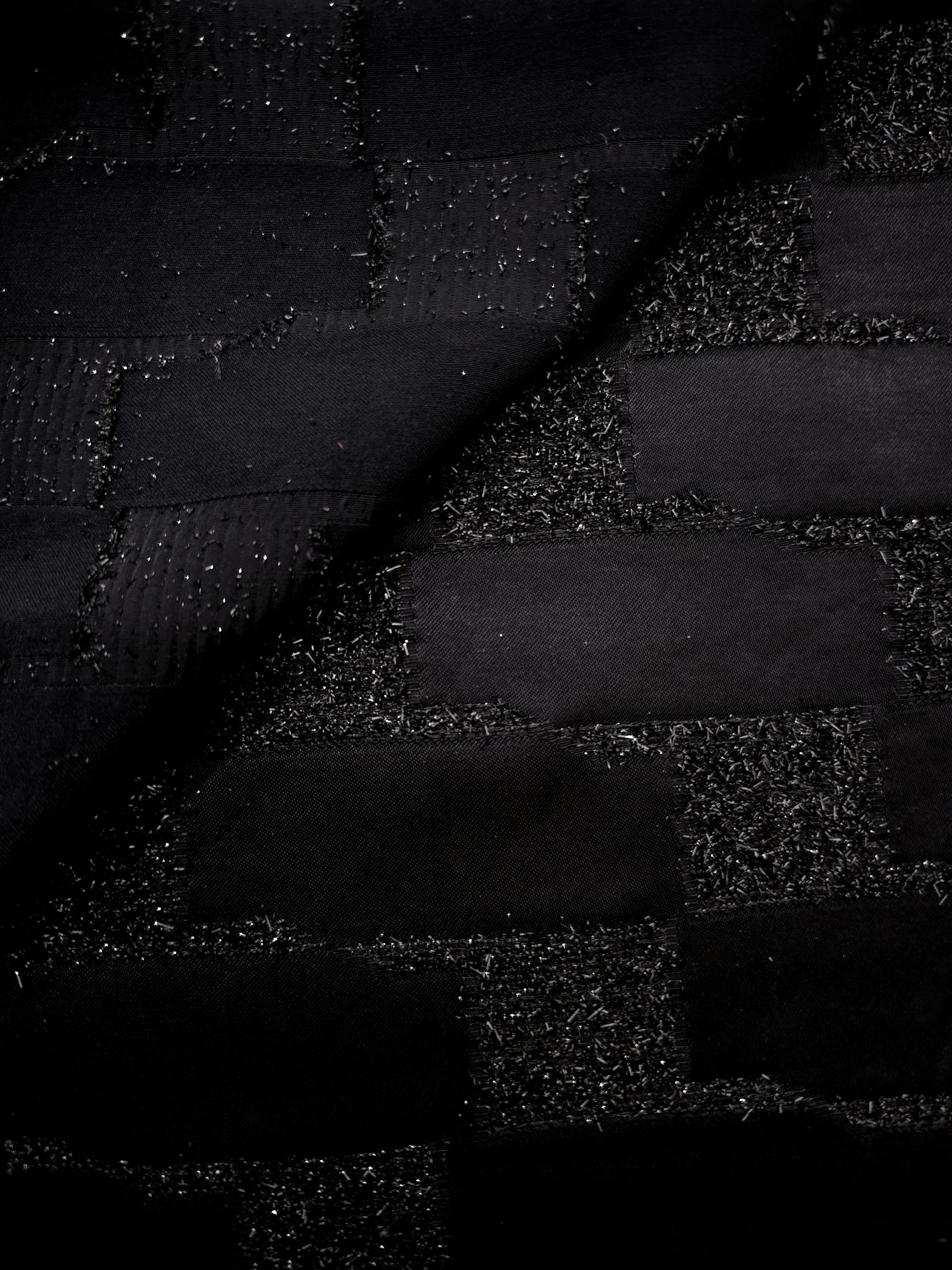Close-up of Metallic Black viscose jacquard with embossed crosshatch basket weave