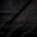 Close-up of Metallic Black viscose jacquard with embossed ripple stripe pattern