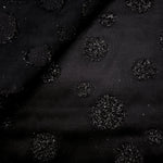 Close-up of Metallic Black viscose jacquard with embossed speckled confetti dots