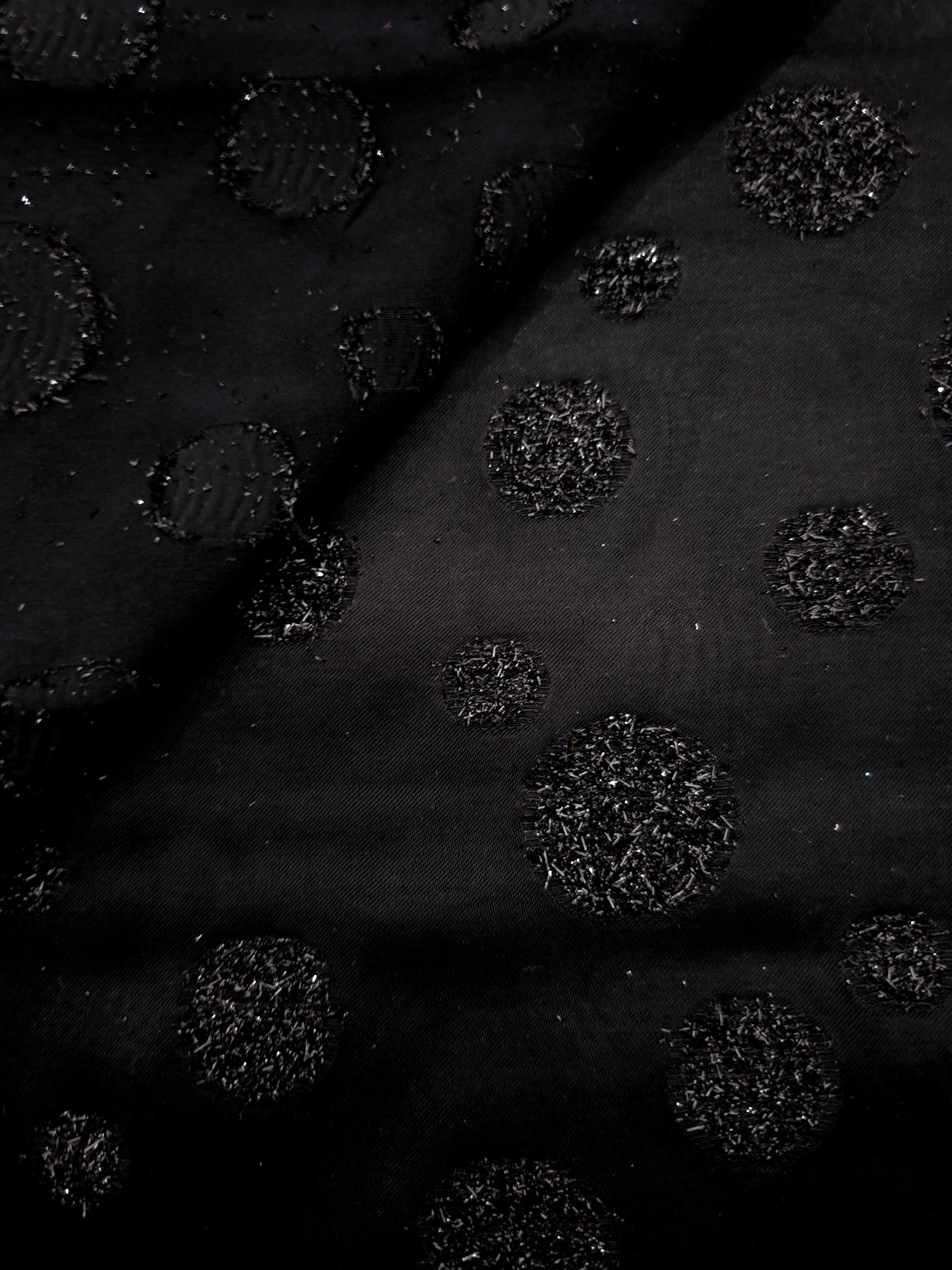 Close-up of Metallic Black viscose jacquard with embossed speckled confetti dots