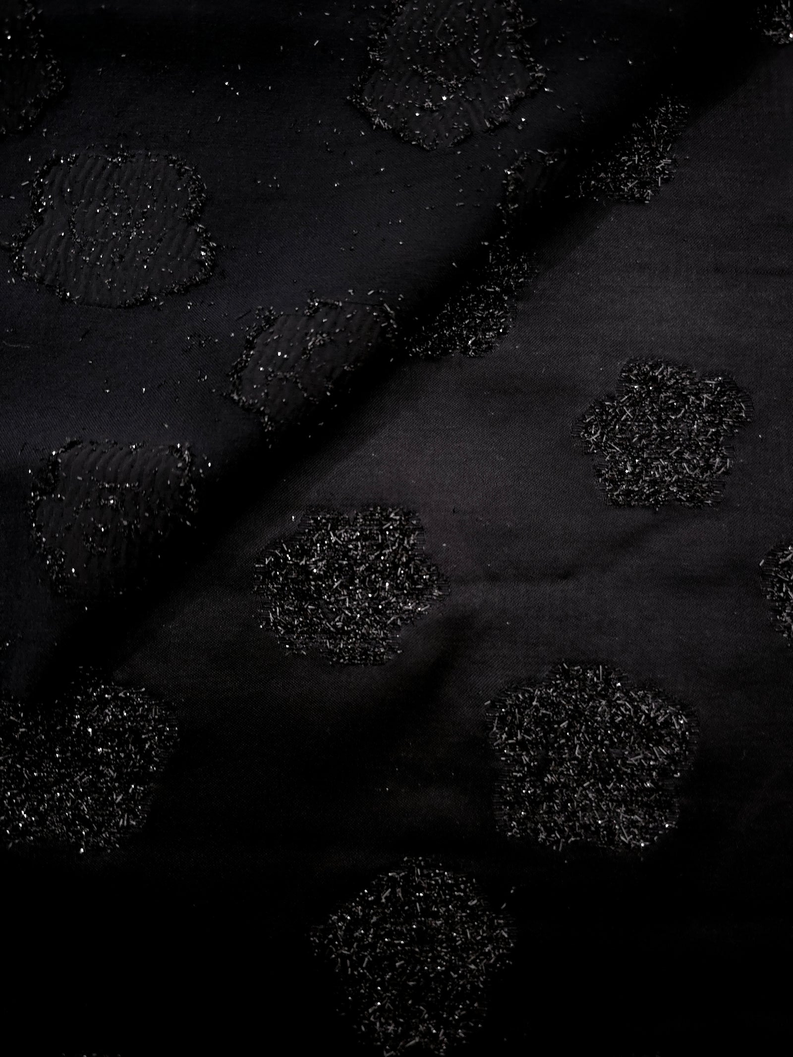Close-up of Metallic Black viscose jacquard with embossed stone dot pattern