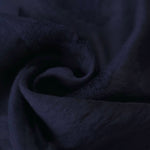 Dark blue big leaf embossed viscose jacquard fabric in a close draped view for sheer overlays.