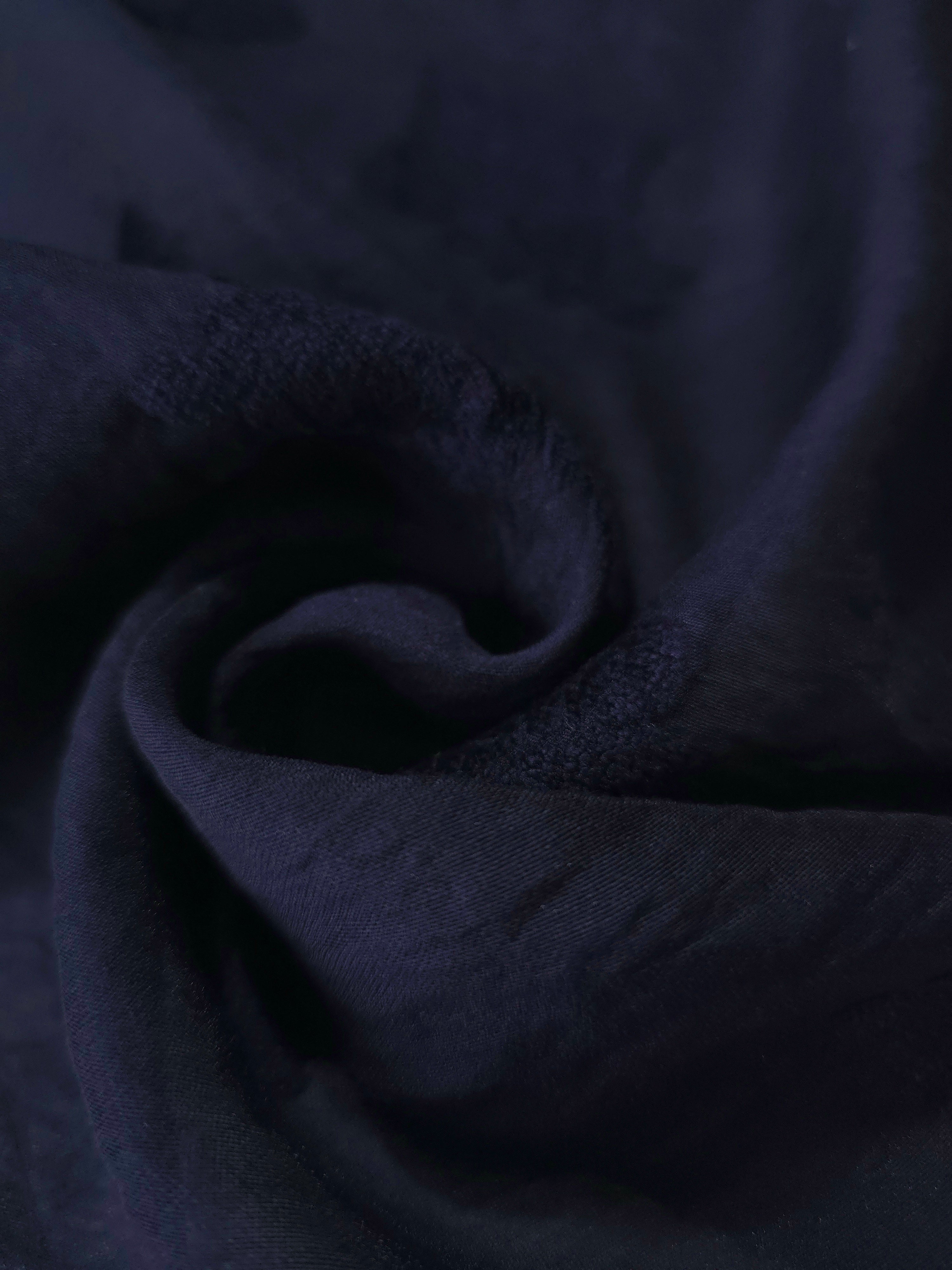 Dark blue big leaf embossed viscose jacquard fabric in a close draped view for sheer overlays.