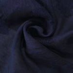 Drape view of dark blue big leaf embossed viscose jacquard fabric for kaftan overlays.