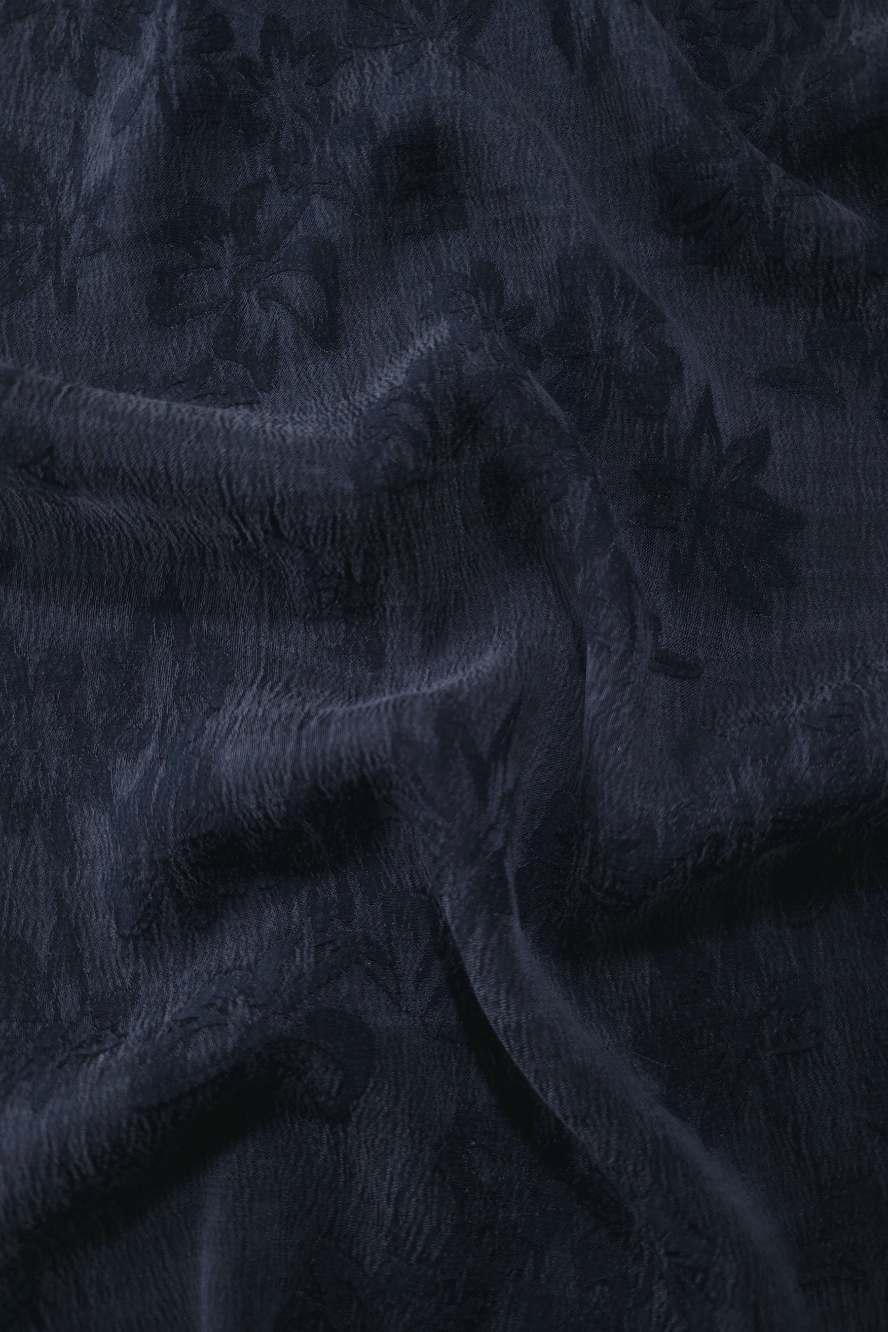 Draped blue lyocell viscose jacquard showing floral sheen for fluid dresses and blouses.