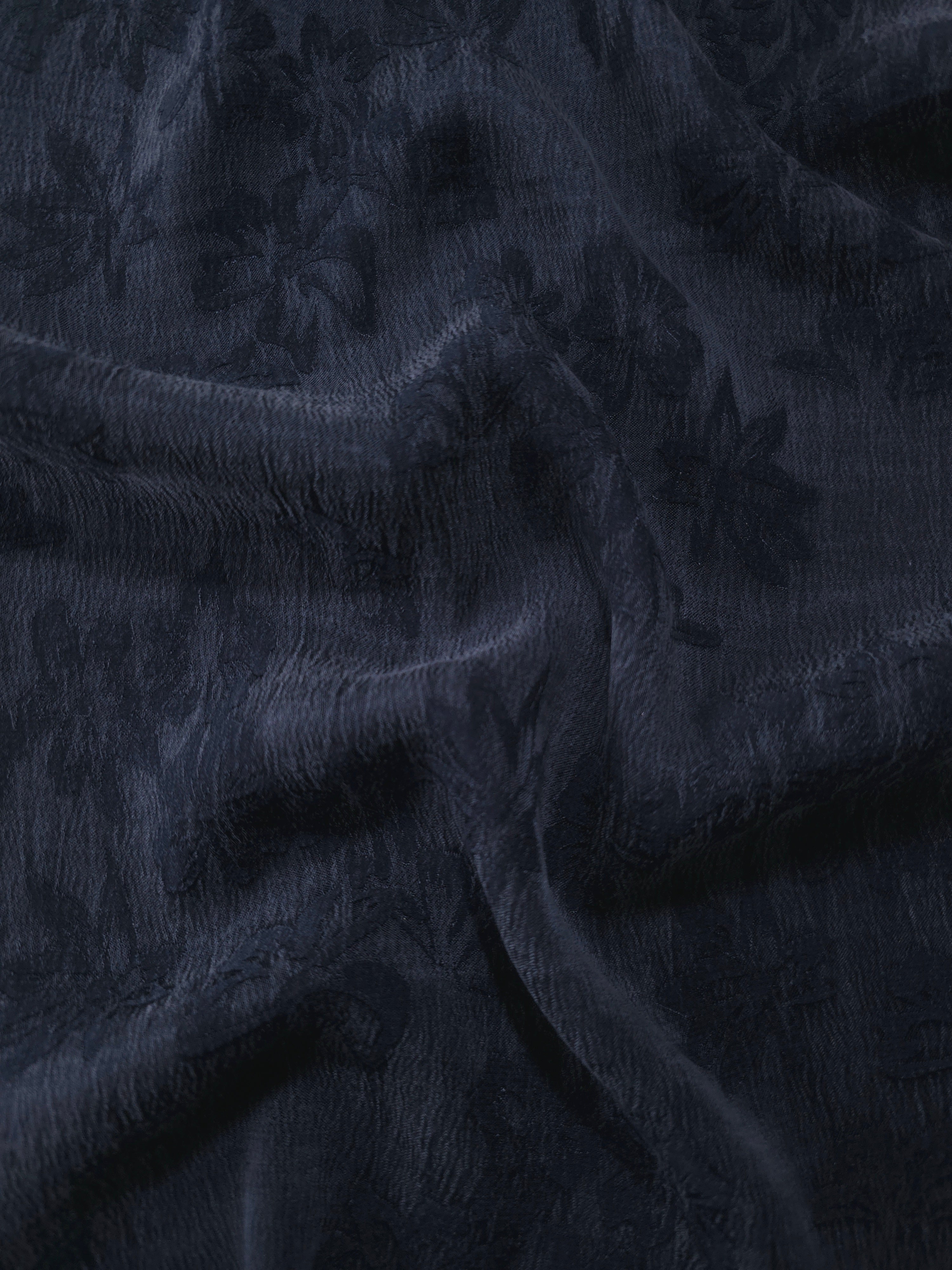 Draped blue lyocell viscose jacquard showing floral sheen for fluid dresses and blouses.