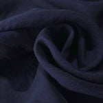 Dark blue flower embossed viscose jacquard fabric in a close draped view for overlays.