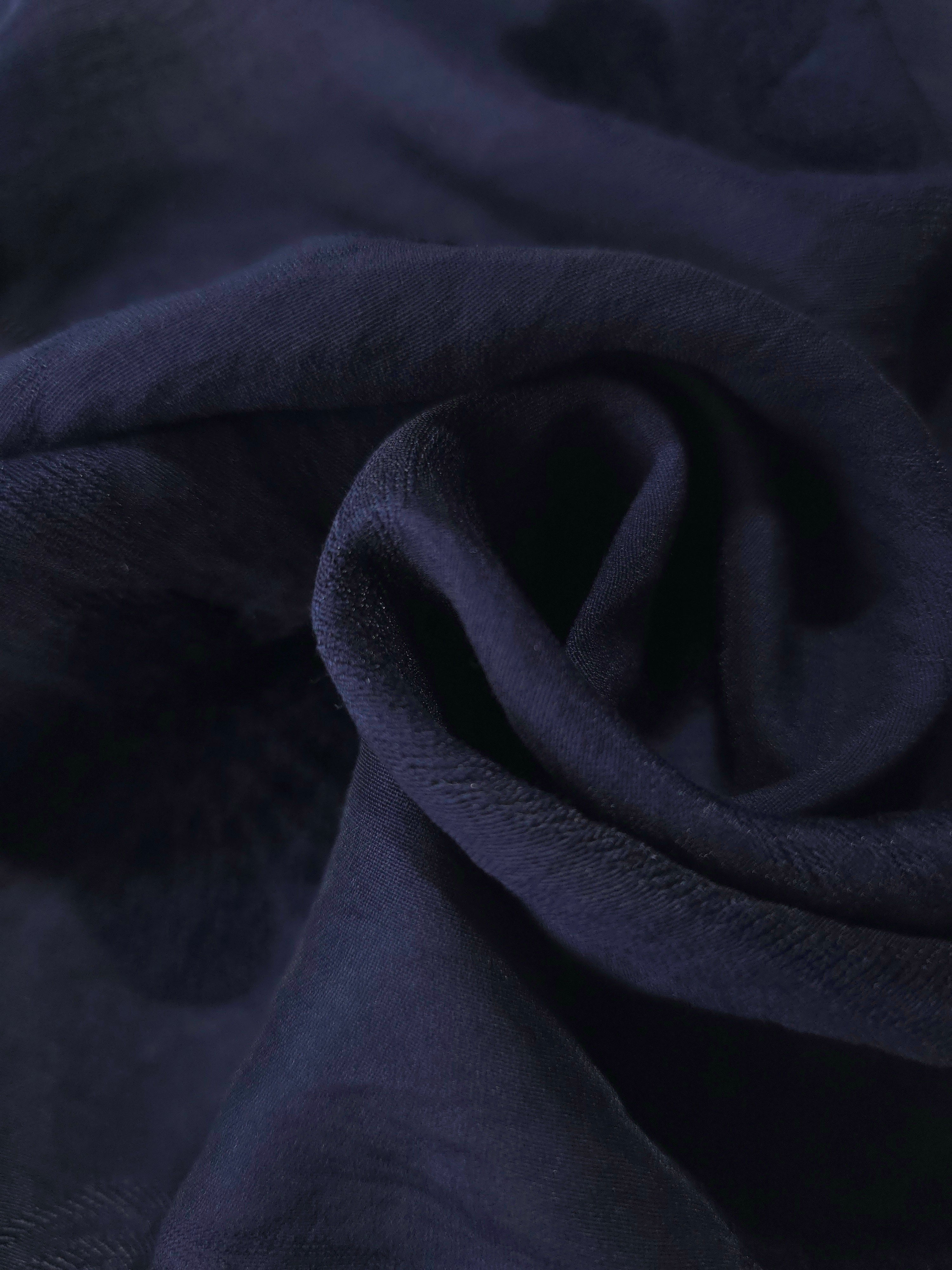 Dark blue flower embossed viscose jacquard fabric in a close draped view for overlays.