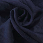 Swirl drape of dark blue flower embossed viscose jacquard fabric for kaftan layers.