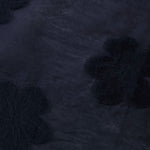 Wave drape of dark blue flower embossed viscose jacquard fabric for layered dresses.
