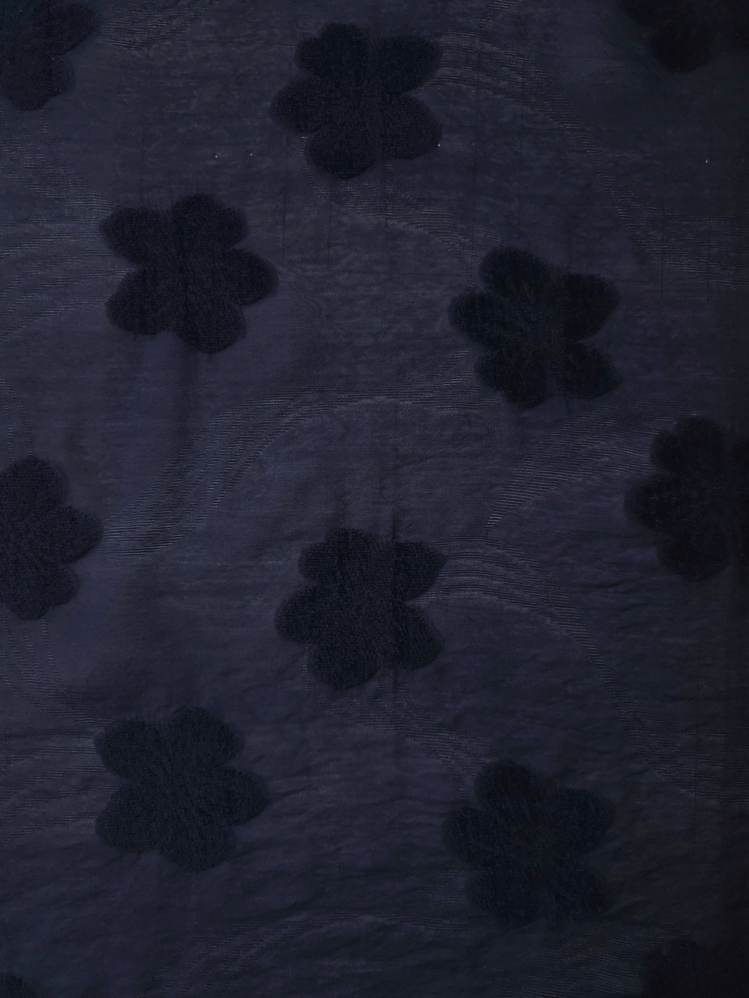 Wide view of dark blue flower embossed viscose jacquard fabric with tonal raised texture.