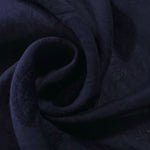 Dark blue leaf embossed viscose jacquard fabric in a close draped view for overlays.