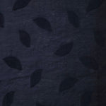 Wide view of dark blue leaf embossed viscose jacquard fabric with tonal raised texture.