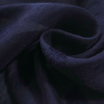 Dark blue small leaf embossed viscose jacquard fabric in a close draped view.