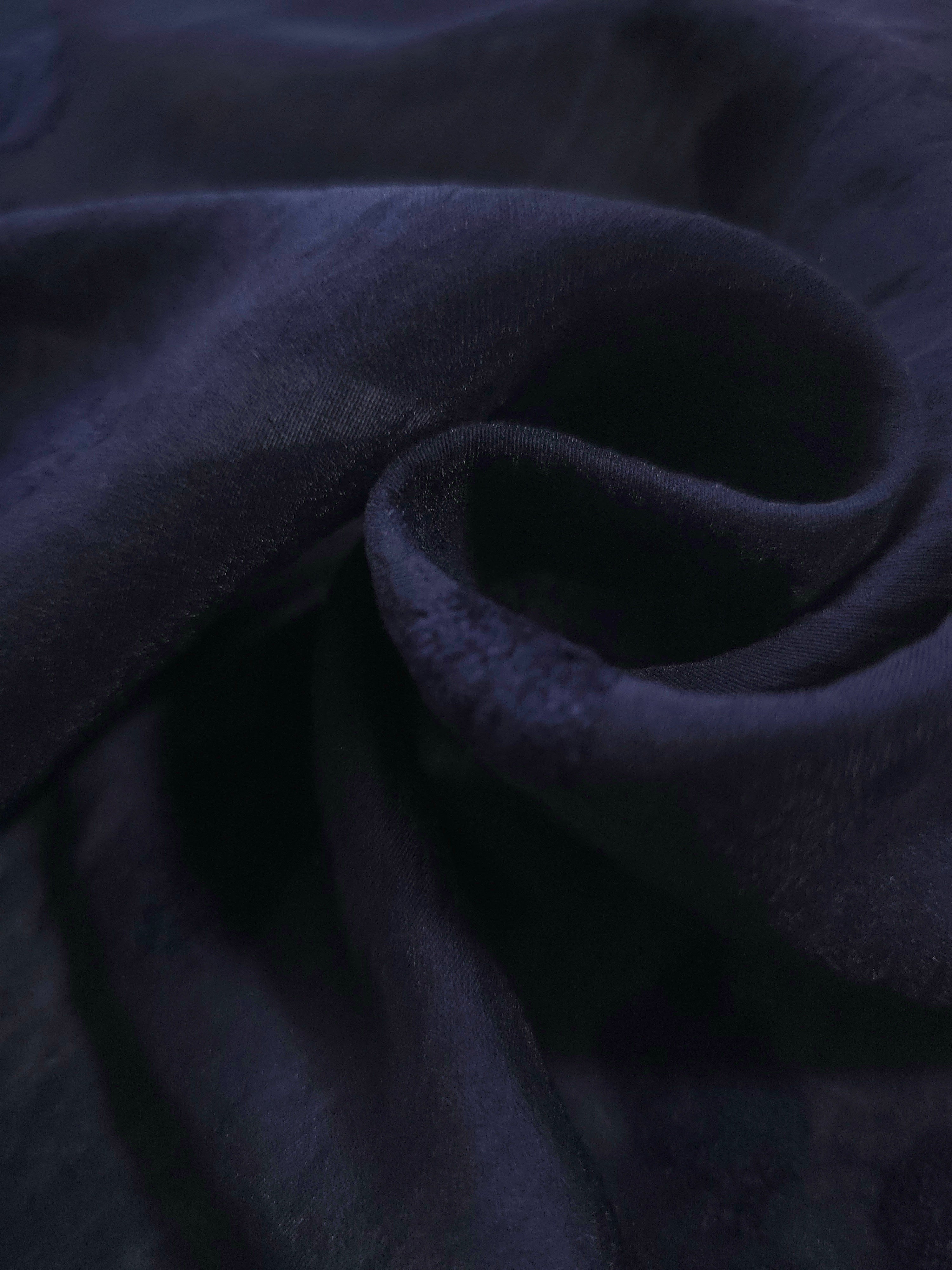 Dark blue small leaf embossed viscose jacquard fabric in a close draped view.