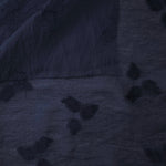 Wide view of dark blue small leaf embossed viscose jacquard fabric with raised motif.