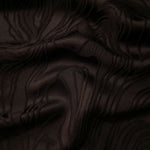 Brown branch polyester crepe jacquard fabric in a textured drape for dresses and tailored layers.