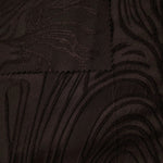Closeup texture of brown branch polyester crepe jacquard fabric for tailored dress layers.