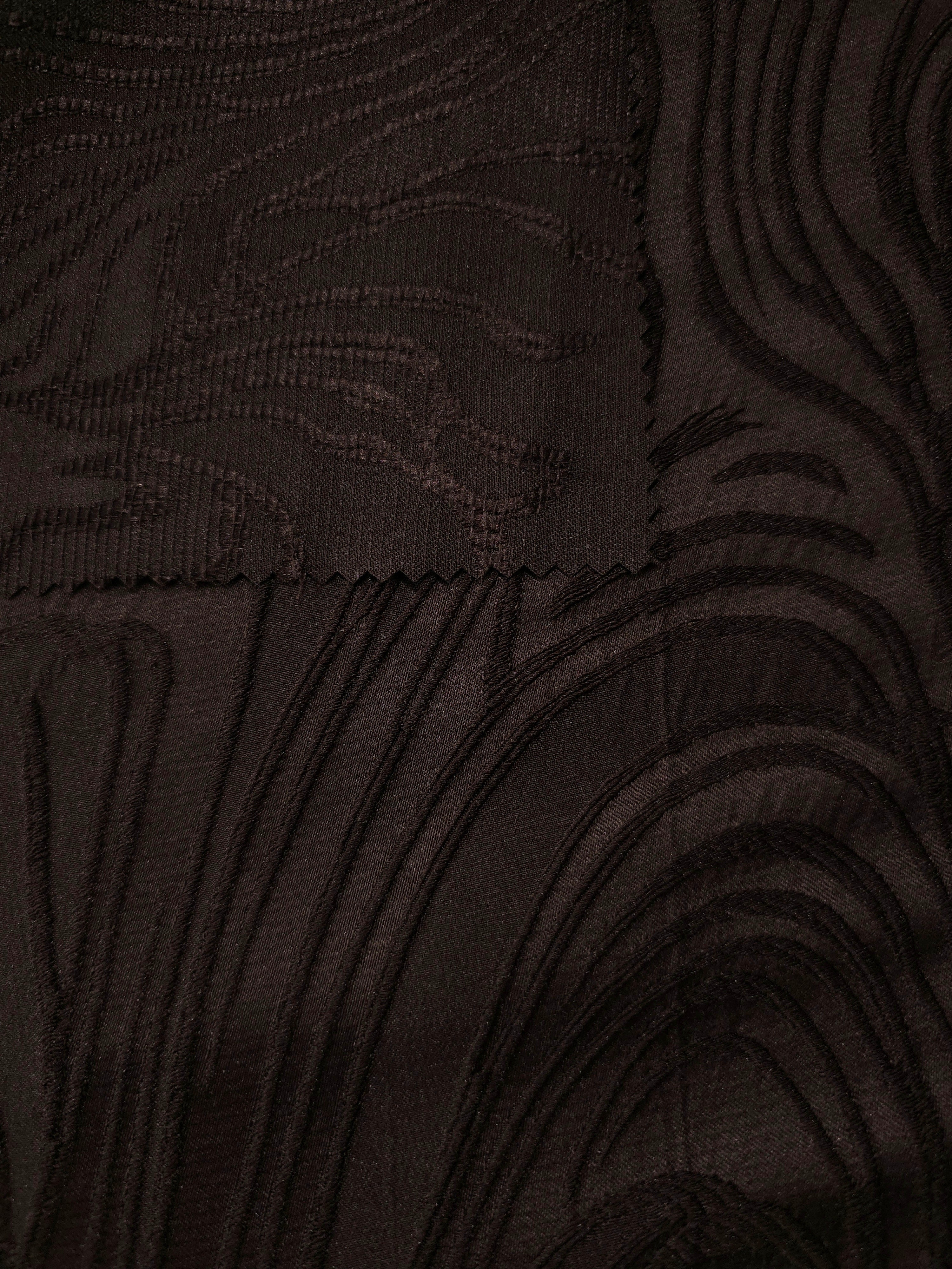 Closeup texture of brown branch polyester crepe jacquard fabric for tailored dress layers.
