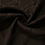 Brown wheat leaf polyester crepe jacquard fabric in a textured drape for dresses and skirts.