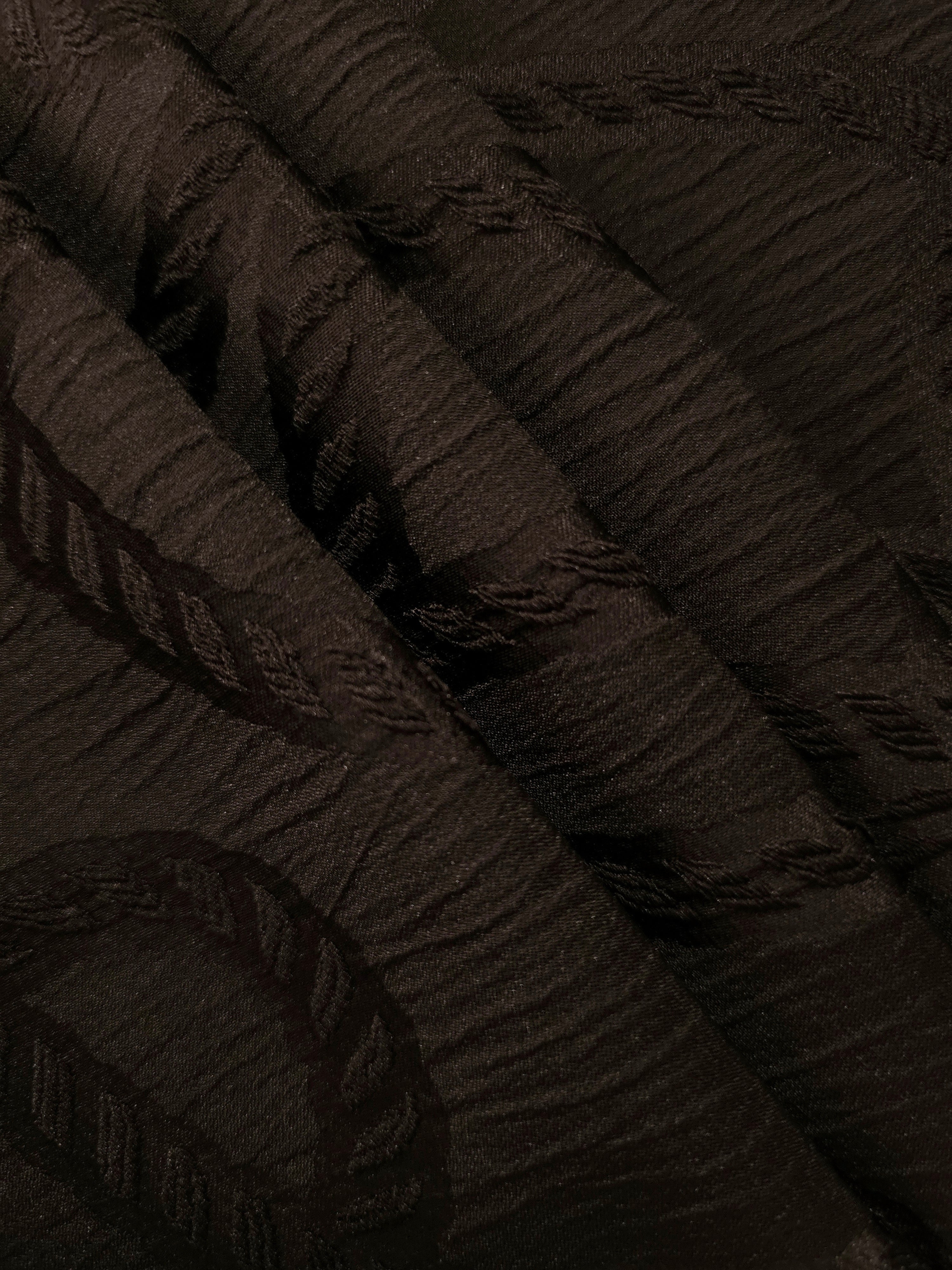 Pattern detail of brown wheat leaf polyester crepe jacquard fabric with raised texture.