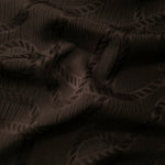 Wide view of brown wheat leaf polyester crepe jacquard fabric for modestwear layers.