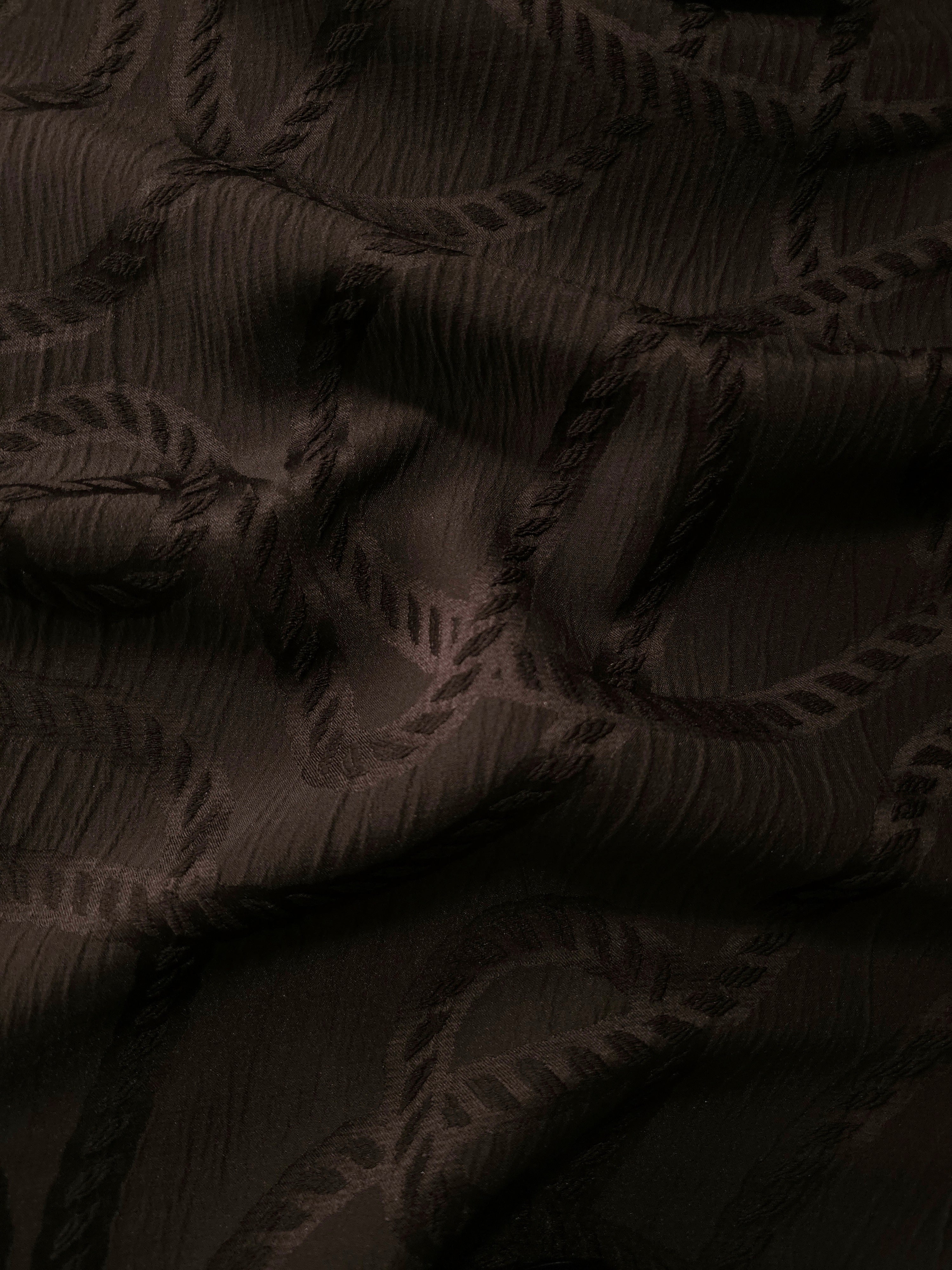 Wide view of brown wheat leaf polyester crepe jacquard fabric for modestwear layers.