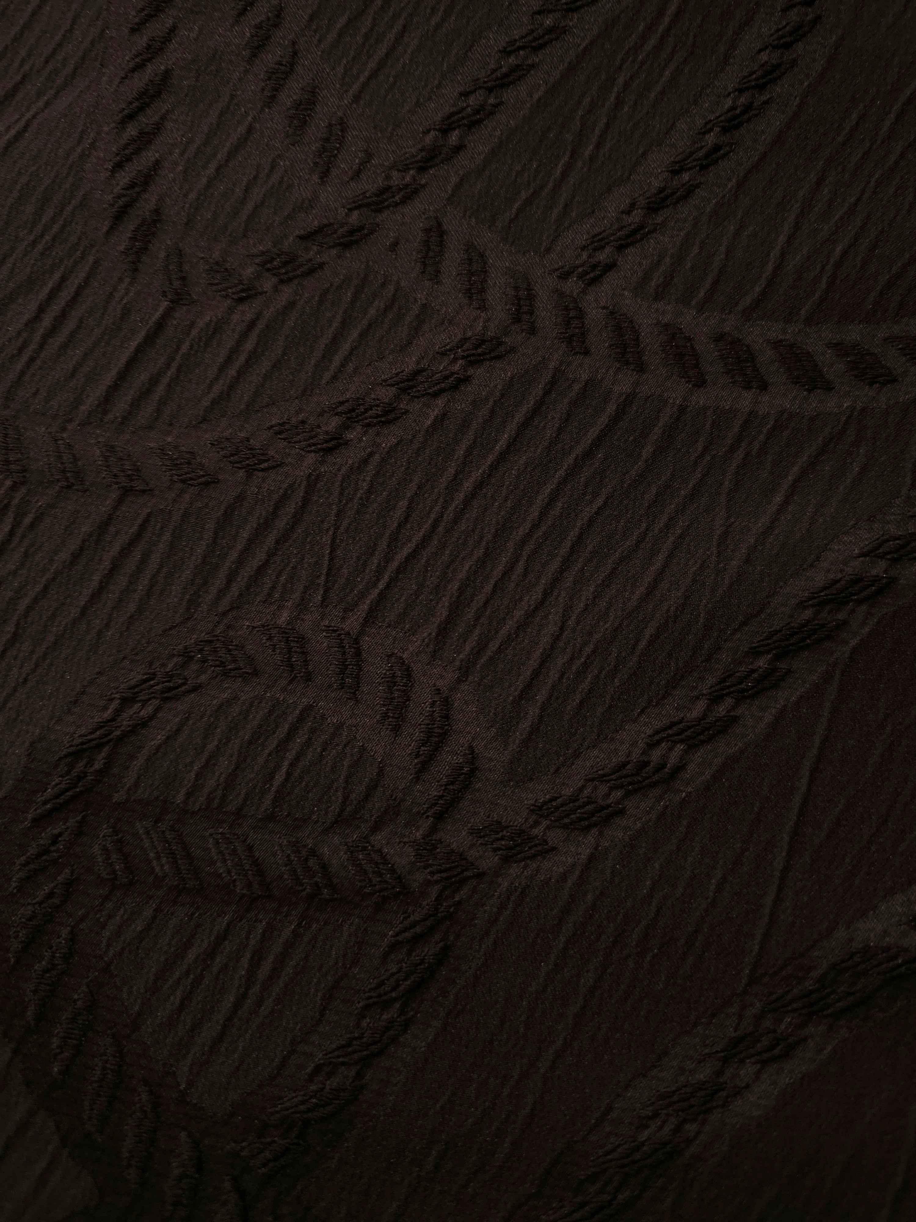 Drape view of brown wheat leaf polyester crepe jacquard fabric for dresses and jackets.
