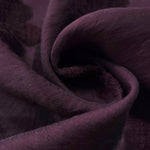 Dark burgundy flower embossed viscose jacquard fabric in a close draped view for sheer overlays.
