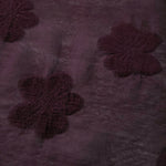 Wave drape of dark burgundy flower embossed viscose jacquard fabric for layered dresses.