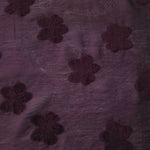 Wide view of dark burgundy flower embossed viscose jacquard fabric with raised motif.