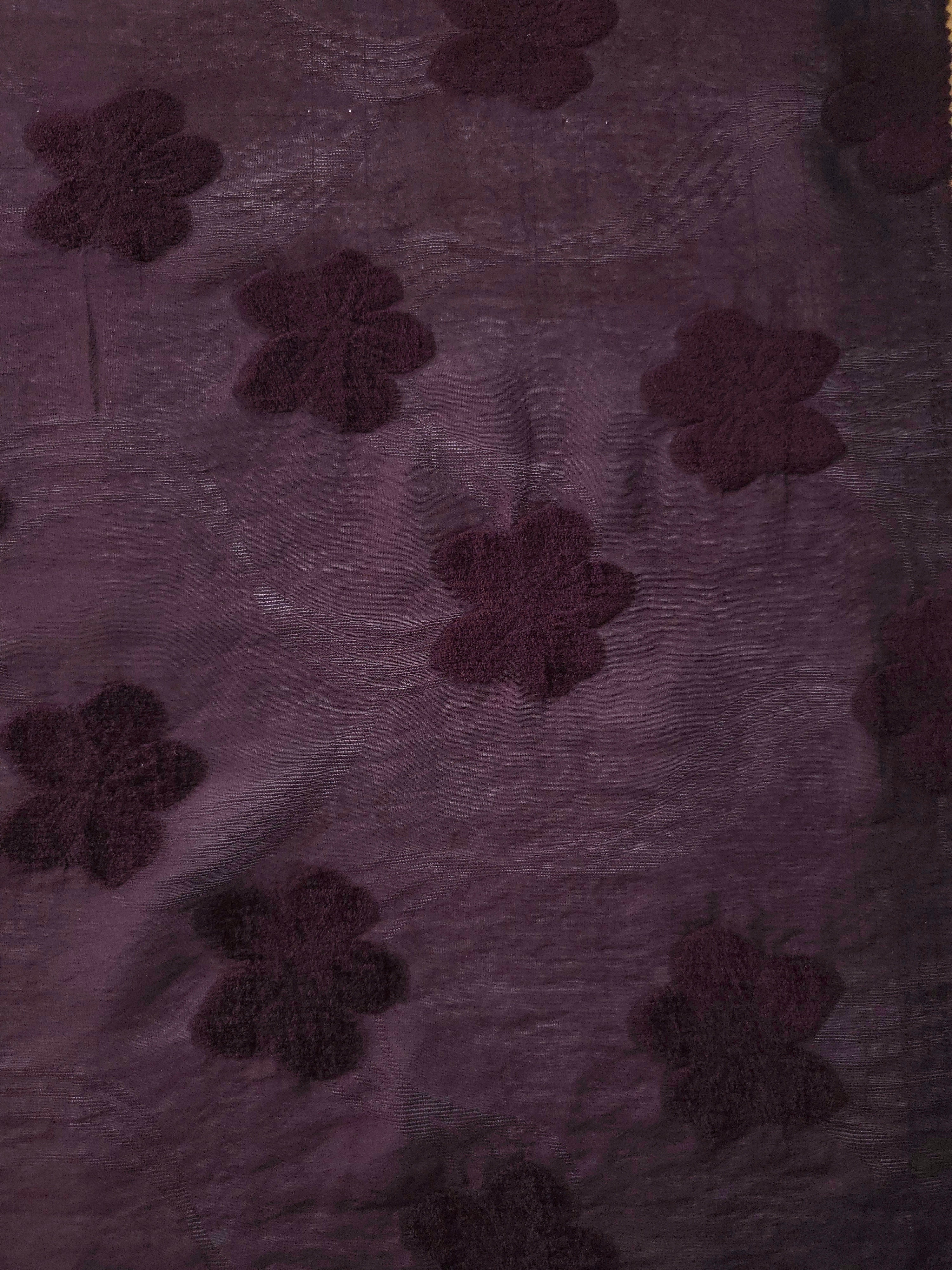 Wide view of dark burgundy flower embossed viscose jacquard fabric with raised motif.