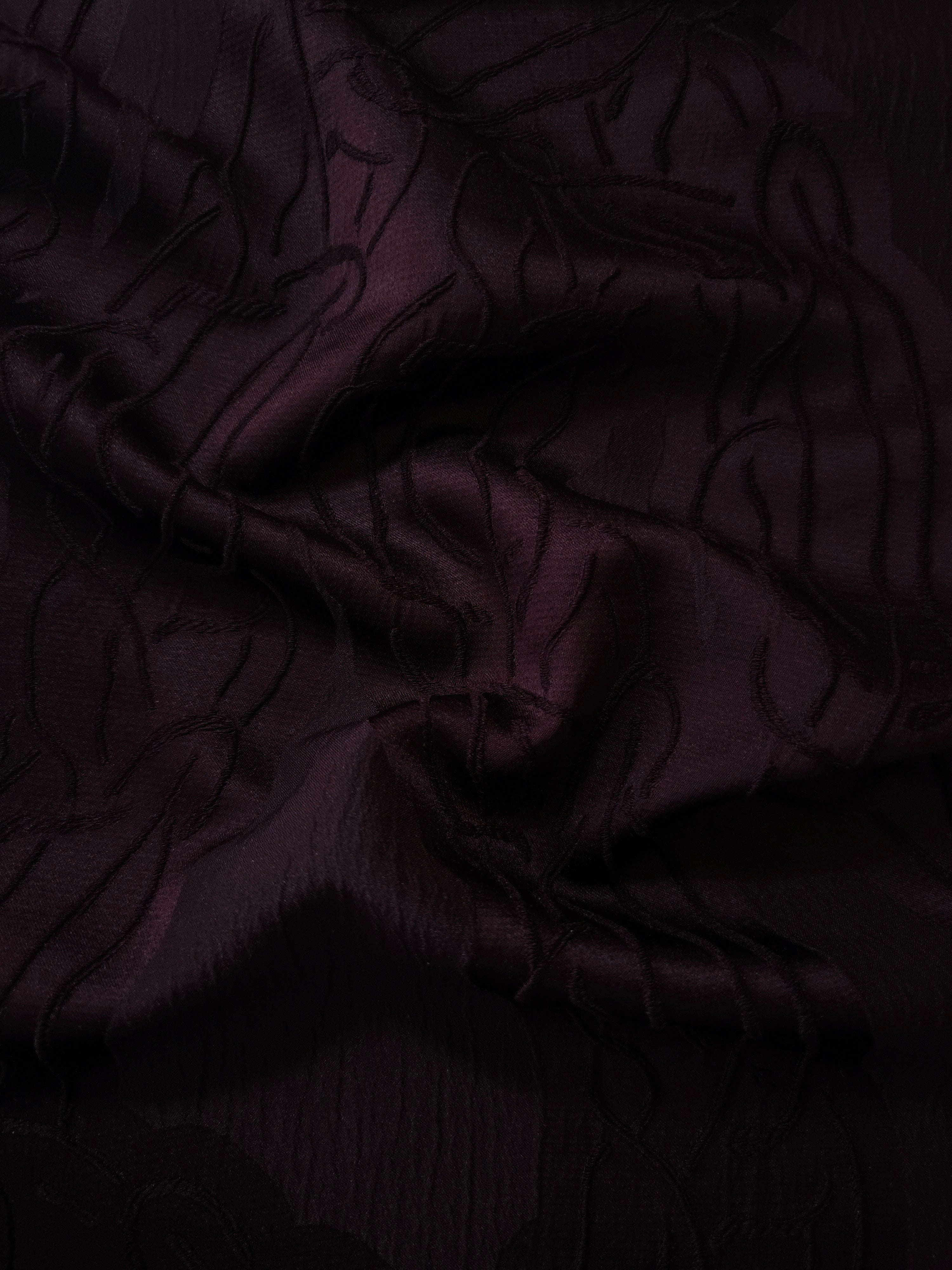 Burgundy laurel polyester crepe jacquard fabric in a textured drape for dresses.