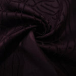 Pattern detail of burgundy laurel polyester crepe jacquard fabric with raised texture.