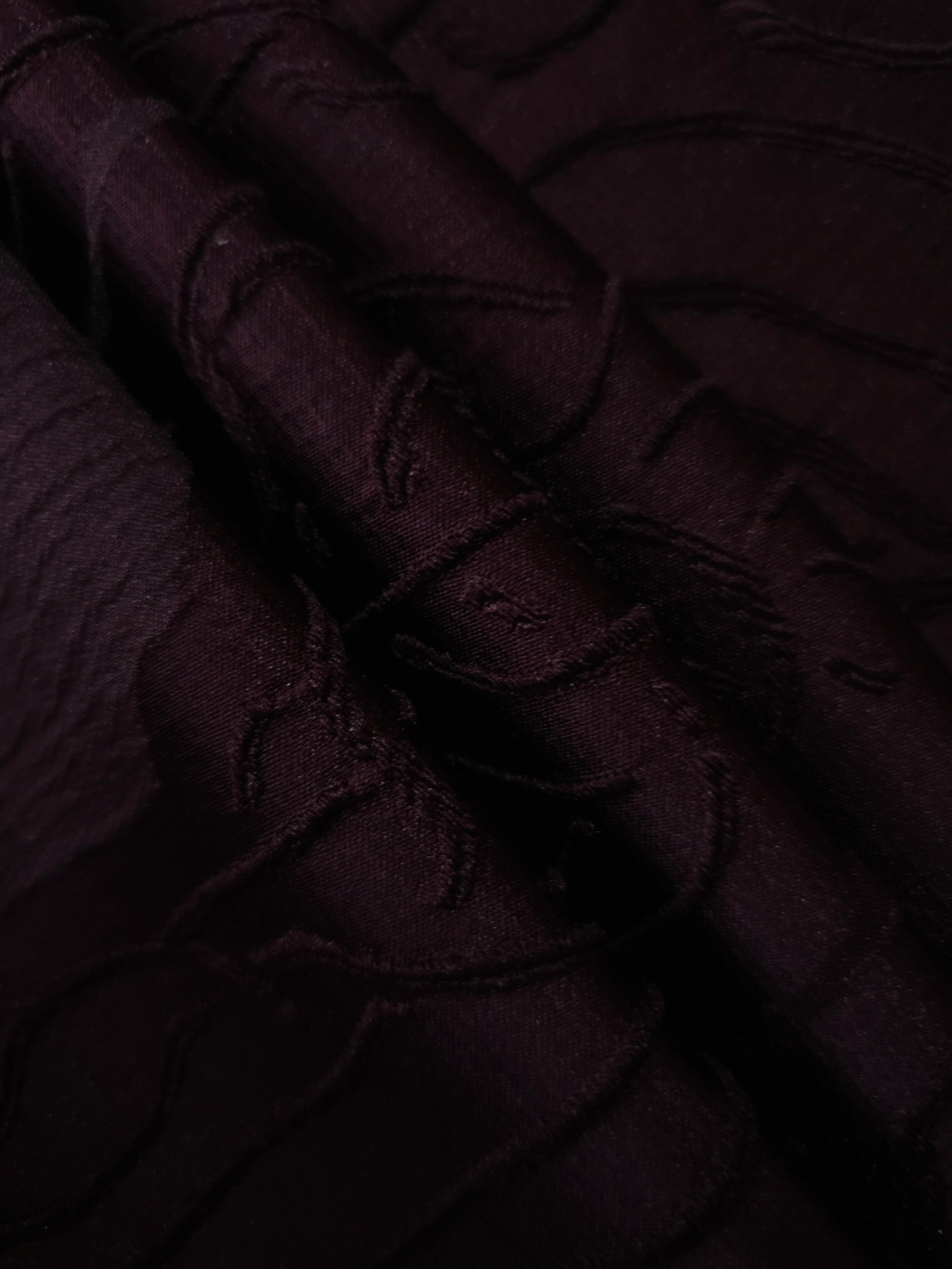 Wide view of burgundy laurel polyester crepe jacquard fabric for occasionwear layers.