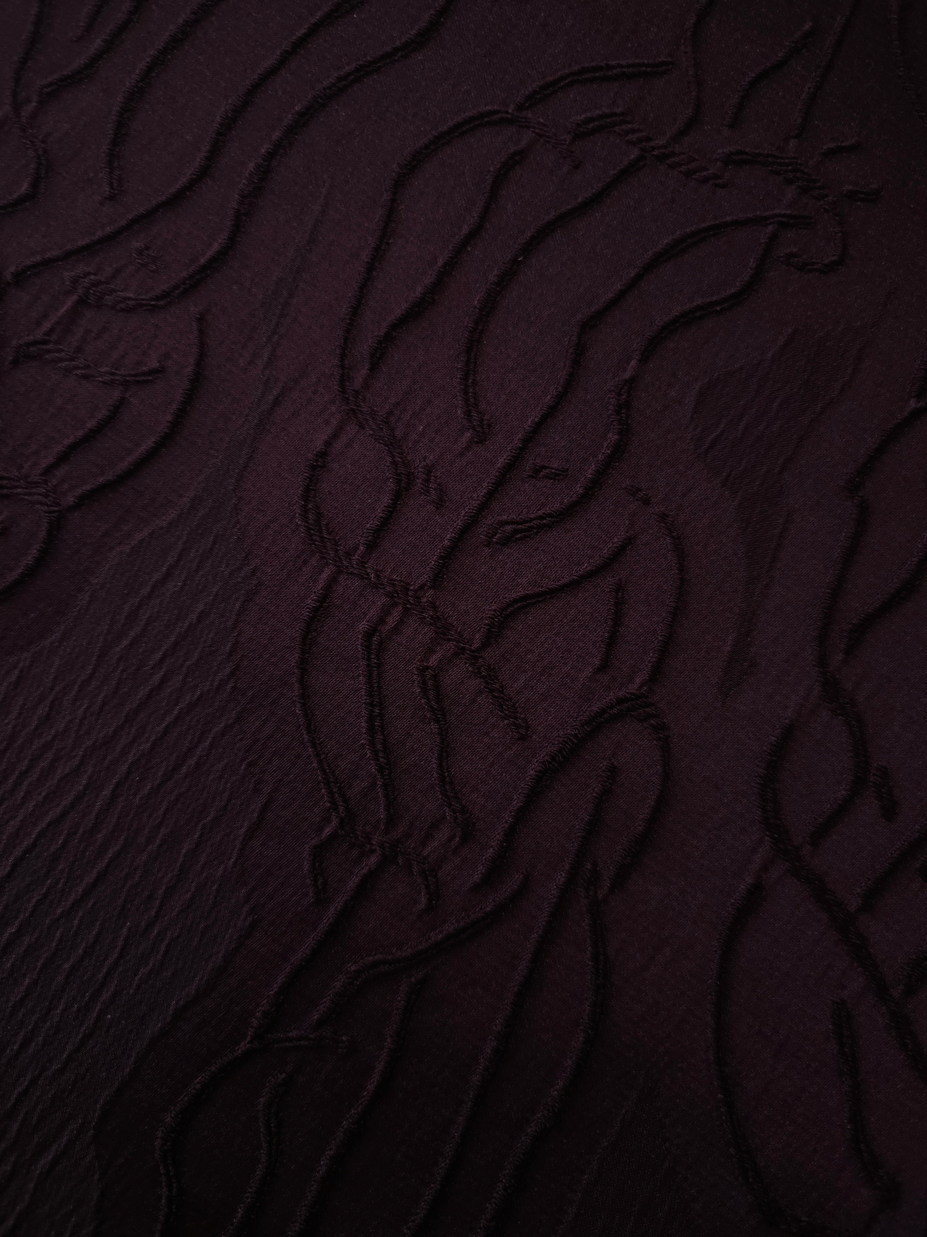 Drape view of burgundy laurel polyester crepe jacquard fabric for dresses and skirts.