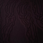 Full view of burgundy laurel polyester crepe jacquard fabric with tonal raised motif.