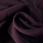 Dark burgundy leaf embossed viscose jacquard fabric in a close draped view for overlays.
