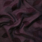 Pattern detail of dark burgundy leaf embossed viscose jacquard fabric with raised motif.