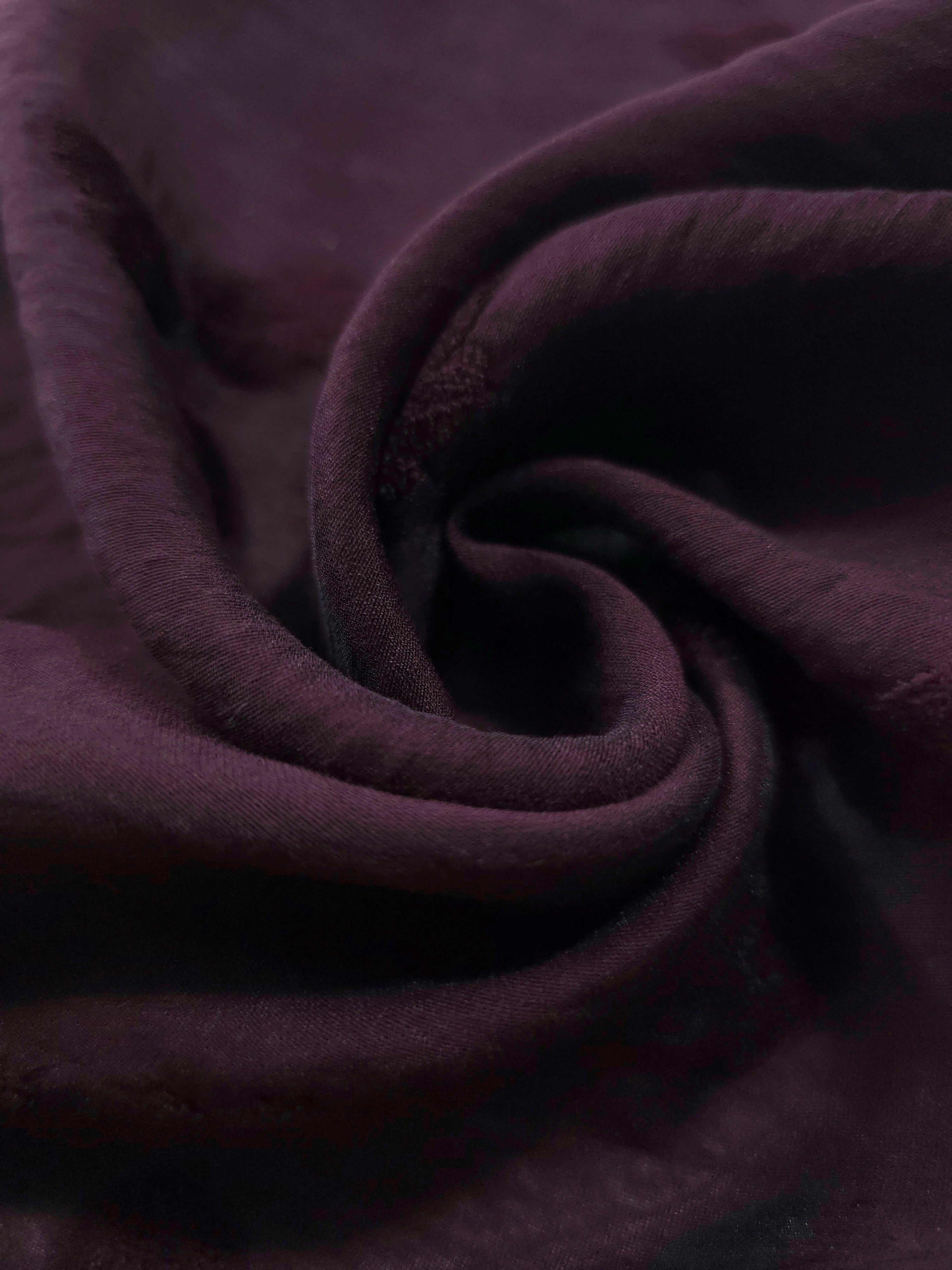 Dark burgundy small leaf embossed viscose jacquard fabric in a close draped view.