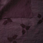 Wide view of dark burgundy small leaf embossed viscose jacquard fabric with raised motif.